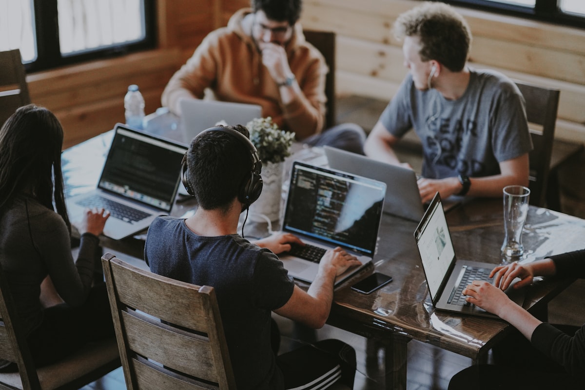 A team collaborating around a shared screen, representing developer collaboration
